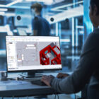 CADMATIC Building Premiumin käyttäjä tarkastelee tietokoneen näyttöä, jossa näkyy tarkka 3D-mallinnus rakennusprojektista.